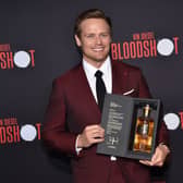 Scottish actor Sam Heughan poses with his newly launched whiskey brand "The Sassenach" as he arrives for the premiere of Sony's "Bloodshot" at the Regency Village theatre on March 10, 2020 in Westwood, California. (Photo by Chris DELMAS / AFP) (Photo by CHRIS DELMAS/AFP via Getty Images)
