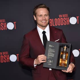 Scottish actor Sam Heughan poses with his newly launched whiskey brand "The Sassenach" as he arrives for the premiere of Sony's "Bloodshot" at the Regency Village theatre on March 10, 2020 in Westwood, California. (Photo by Chris DELMAS / AFP) (Photo by CHRIS DELMAS/AFP via Getty Images)