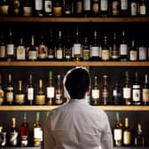 Man looking at many bottles of whisky
