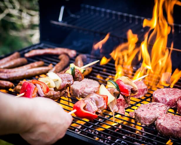 Detail Of Beef Burgers and sausages Cooking On A Barbecue