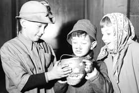 Edinburgh guisers warm their hands over their tumshie lantern in 1956. Picture: TSPL