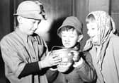 Edinburgh guisers warm their hands over their tumshie lantern in 1956. Picture: TSPL