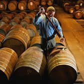 A worker at Bruichladdich distillery takes a whisky sample from a single cask. Picture: Getty