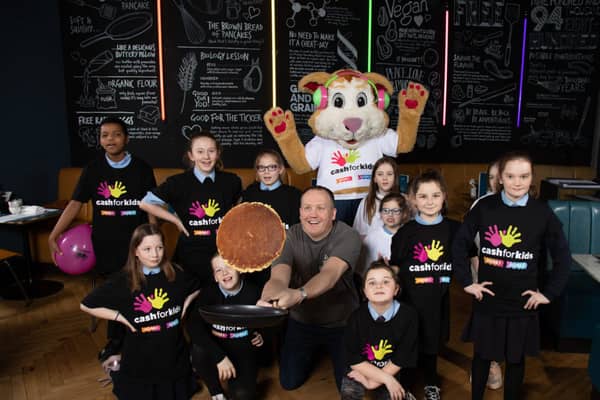 Owner Paul Reynolds flips a pancake with the pupils from St Roch's Primary School and Courage The Cat from CHAS. Photograph: Martin Shields