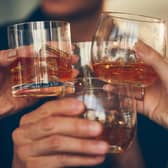 Three,People,Makes,A,Toast,With,Whiskey