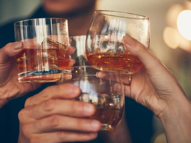 Three,People,Makes,A,Toast,With,Whiskey