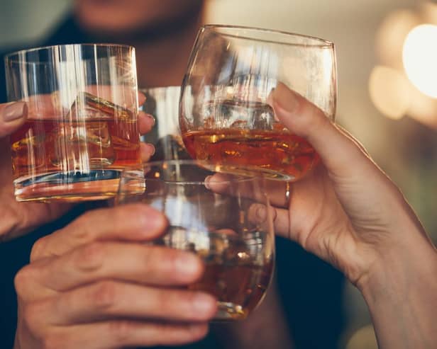 Three,People,Makes,A,Toast,With,Whiskey