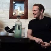 21/02/2023. Glasgow. THE UBIQUITOUS CHIP, Ashton Lane.

Portrait of actor, Sam Heughan for article by Rosiland Erskine in Scran.

Sam Roland Heughan (/ËahjuËÉ™n/; born 30 April 1980) is a Scottish actor, producer, author, and entrepreneur. He is best known for his starring role as Jamie Fraser in the Starz drama series Outlander (2014â€“present) for which he has won the People's Choice Award for Favorite Cable Sci-Fi/Fantasy TV Actor and the Saturn Award for Best Actor on Television, and received a nomination for the Critics' Choice Television Award for Best Actor in a Drama Series.

Heughan has also starred in films such as the spy comedy The Spy Who Dumped Me (2018), The Empty Train, and the superhero action film Bloodshot (2020). Among his numerous plays he was nominated for the Laurence Olivier Award for Most Promising Performer for his performance in Outlying Islands performed at the Royal Court Theatre Upstairs.[1][2]

Heughan and his Outlander co-star Graham McTavish co-wrote Clanlands: Whisky, Warfare, and a Scottish Adventure Like No Other[3] which reached number one on the New York Times' Best Seller List for hardcover nonfiction, and combined print and e-book nonfiction in November 2020.[4] The same year Heughan launched his own whisky brand, The Sassenach (named after his Outlander character's nickname for his wife, Claire[5]), winning consecutive double golds in the 2020 and 2021 San Francisco World Spirits Competition.