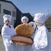 Ayrshire butcher We hae meat has created the ‘world’s largest’ square sausage slice to mark the inaugural National Square Sausage Day, taking place on 25 March. Pictured with the enormous square sausage, in its roll produced by The Breadwinner Bakery, are Jamie (8), Daisy (8) and Leo (9) from Dailly Primary School’s P4 & 5 class.