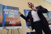 Ulrich Siegmund, of the far-right Alternative for Germany (AfD) party, poses with an election poster reading 'deportations starting minute one' (Picture: Sean Gallup)