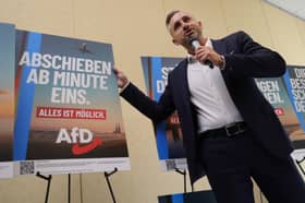 Ulrich Siegmund, of the far-right Alternative for Germany (AfD) party, poses with an election poster reading 'deportations starting minute one' (Picture: Sean Gallup)