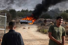 A car burns after clashes between Israeli settlers and Palestinians outside the occupied West Bank village of Turmos Ayya near Ramallah in October last year (Picture: Hazem Bader)