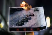 A man at a candlelight vigil in Hong Kong in 2020 holds a photograph of the famous 'Tank Man' standing in front of a column of Chinese tanks in Tiananmen Square, Beijing, in June 1989 (Picture: Anthony Wallace)