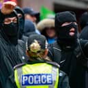 Wearing balaclavas to hide their identities, anti-immigration protesters stage a counter-demonstration during an anti-racism rally in Glasgow in June (Picture: Jeff J Mitchell)
