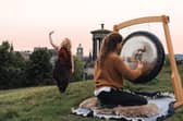 Madeleine Schmoll of The Scotch Malt Whisky Society raising a toast to the start of whisky season on Calton Hill, Edinburgh, with Jo McCoy of Blissness, a gong sound bath practitioner
