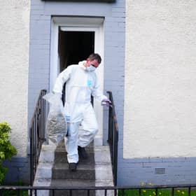 A forensic officer carrying a evidence bag containing what is believed to be cannabis after police officers raided a property in Springburn, Glasgow.