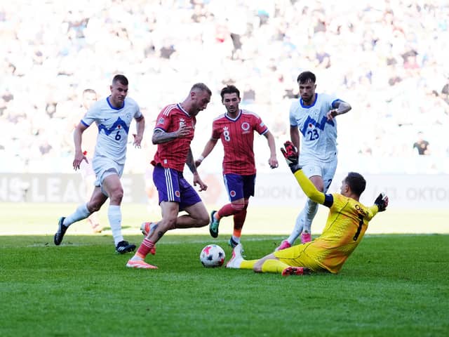 Slovenia goalkeeper Jan Oblak saves at the feet of Scotland's Oliver McBurnie.