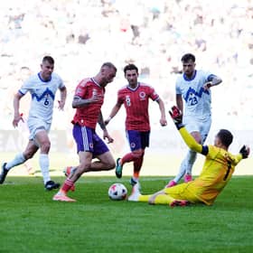 Slovenia goalkeeper Jan Oblak saves at the feet of Scotland's Oliver McBurnie.