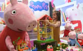 A young girl called Daria plays with Peppa Pig toys at an international toy fair in Germany (Picture: Christof Stache)
