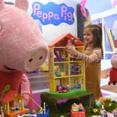 A young girl called Daria plays with Peppa Pig toys at an international toy fair in Germany (Picture: Christof Stache)