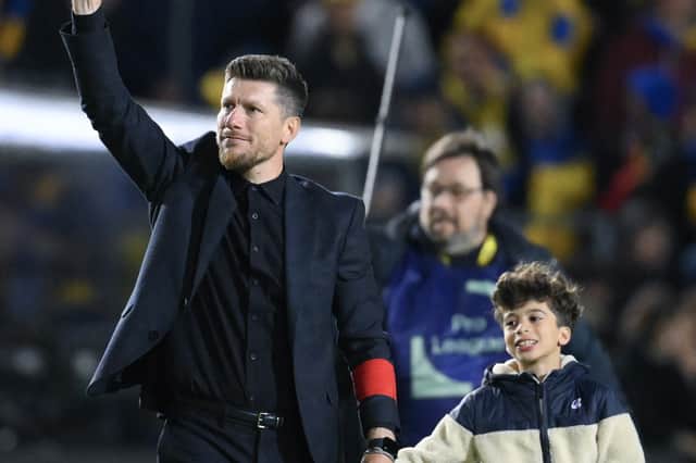 Union SG head coach Sebastien Pocognoli celebrates as he leaves the pitch with his son after winning the Belgian "Pro League" First Division playoff against Genk at the Joseph Marien Stadium, in Brussels on May 3, 2025.