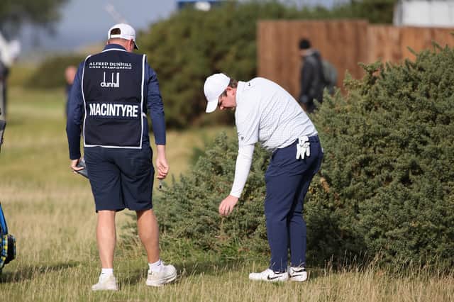 Bob MacIntyre takes a penalty drop after finding a gorse bush with his tee shot on the second hole on the Old Course at St Andrews