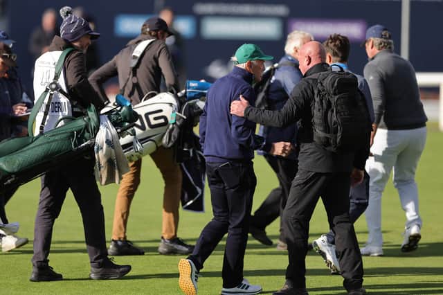 Dermot Desmond being escorted off by security from the 18th green