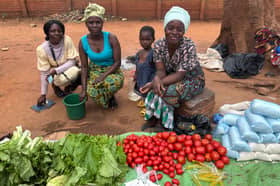 From left, Madalitso, Alefa, two-year-old Iana, and her mother Brenda, at the side of a road in Area Three, Lilongwe. Madalitso sells airtime vouchers for Airtel Malawi, while Alefa and Brenda have a stall selling the essentials of life: maize flour, tomatoes, greens and cooking oil.