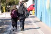 Iranian students, carrying their school backpacks, walk along a street during the first day of school year in Tehran