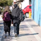 Iranian students, carrying their school backpacks, walk along a street during the first day of school year in Tehran