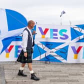 An independence supporter carries a Scottish flag outside the SNP conference in Aberdeen. Picture: Paul Reid