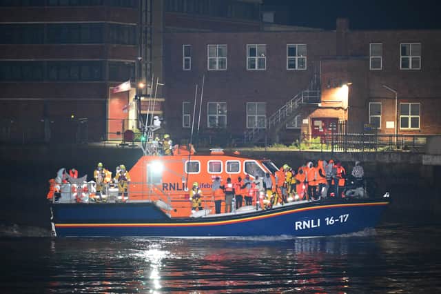 An RNLI lifeboat arrives carrying migrants in Gosport on October 4 amid protests by anti-migrant activists. Picture: Finnbarr Webster