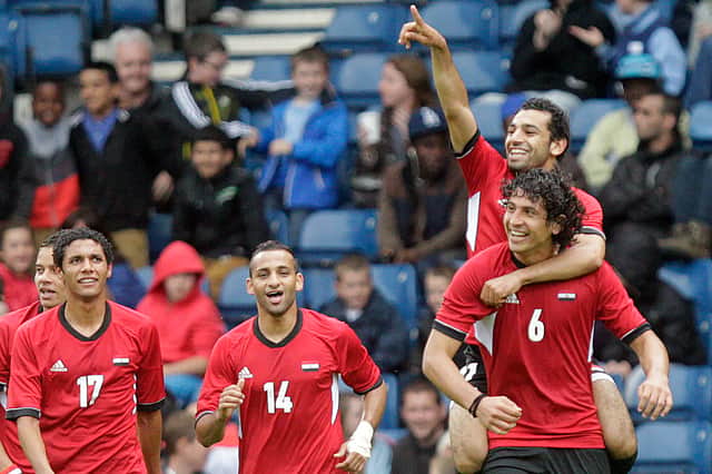 Egypt's Mohamed Salah (top) points as he celebrates on the shoulders of Ahmed Hegazi after scoring his team's first goal against Belarus during the London 2012 Olympic Games men's football match at Hampden Park, Glasgow, on August 1, 2012.
