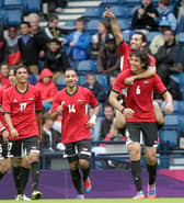 Egypt's Mohamed Salah (top) points as he celebrates on the shoulders of Ahmed Hegazi after scoring his team's first goal against Belarus during the London 2012 Olympic Games men's football match at Hampden Park, Glasgow, on August 1, 2012.