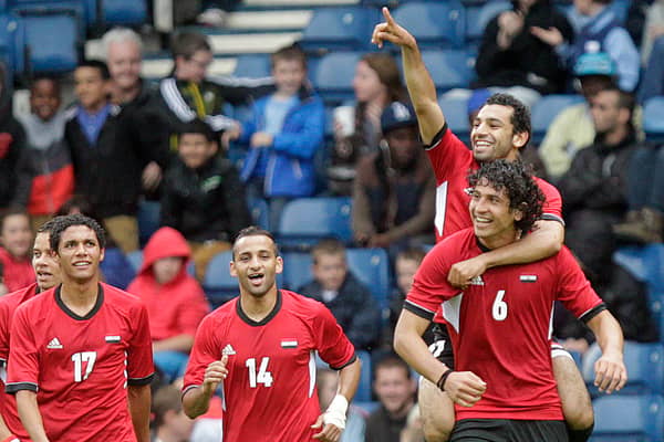 Egypt's Mohamed Salah (top) points as he celebrates on the shoulders of Ahmed Hegazi after scoring his team's first goal against Belarus during the London 2012 Olympic Games men's football match at Hampden Park, Glasgow, on August 1, 2012.
