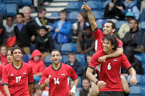 Egypt's Mohamed Salah (top) points as he celebrates on the shoulders of Ahmed Hegazi after scoring his team's first goal against Belarus during the London 2012 Olympic Games men's football match at Hampden Park, Glasgow, on August 1, 2012.