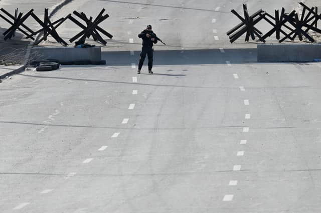 A Ukrainian soldier stands guard at a checkpoint on the outskirts of Kyiv in March 2022, shortly after Russia's full-scale invasion of the country. Picture: Sergei Supinsky