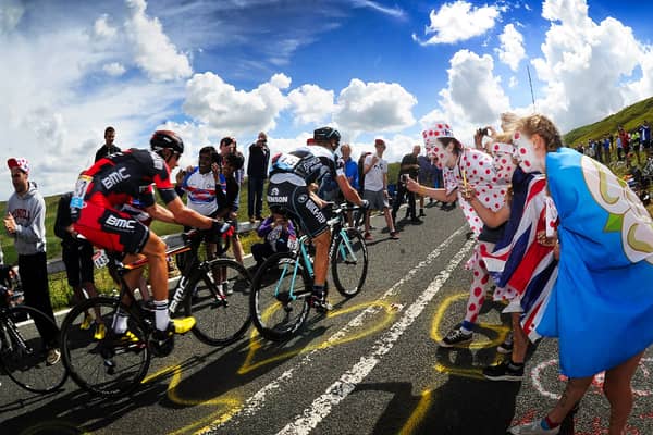 Picture by Simon Hulme/YPN - 06/07/2014 - Cycling - Tour de France 2014: Stage 2, York to Sheffield - Yorkshire, England - Crowds cheer on the cyclist's as they head up the gruelling Holme Moss Climb, Holme Moss Dale, West Yorkshire in the Yorkshire Grand Depart of the 2014 Tour de France. 6th July 2014 -  Cycling fans spectators, flags line the route -

The Grand Depart of the Tour de France 2027 and The Grand Depart of the Tour de France Femmes avec Zwift 2027. Both Races will start in the United Kingdom and visit Scotland, Wales and England - ALL IMAGES © www.SWpix.com ( Photography Hub Ltd ) from the SWpix.com photography archive - MANDATORY BYLINE/PHOTO CREDIT to Photographers Name/SWpix.com/LeTourGB (strictly editorial use only - contact for commercial - simon@swpix.com )