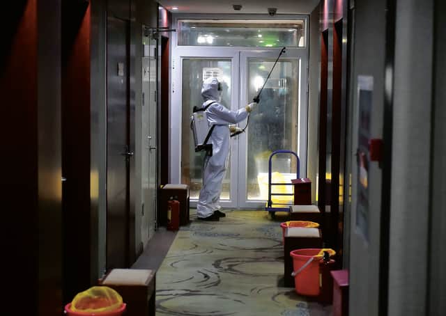 A worker in a protective suit disinfects a corridor of a Beijing hotel that has been converted to an observation and quarantine area. Picture: Chen Zhonghao/Xinhua via AP