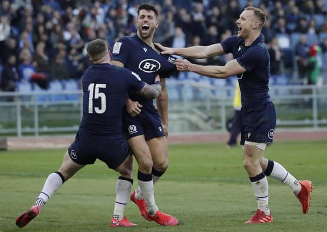 Scotland's Adam Hastings, centre, celebrates his late try with Stuart Hogg, left, and Rory Hutchinson. Picture: Alessandra Tarantino/AP