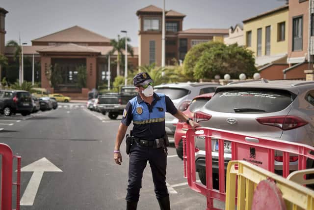 A Spanish police officer sets a barrier blocking the access to the H10 Costa Adeje Palace hotel. Picture: AP