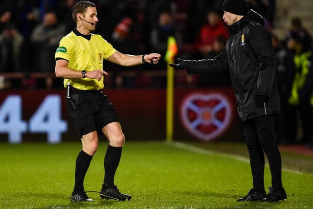 Referee Steven McLean hands the object to fourth official Willie Collum. Picture: SNS