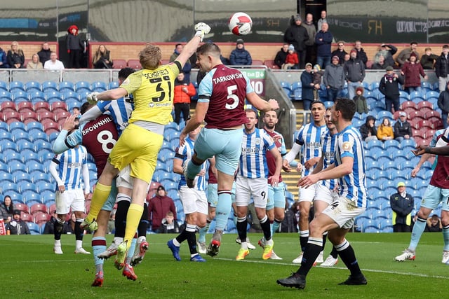 Huddersfield Town's Ryan Schofield punches clear under pressure from Burnley's James Tarkowski.