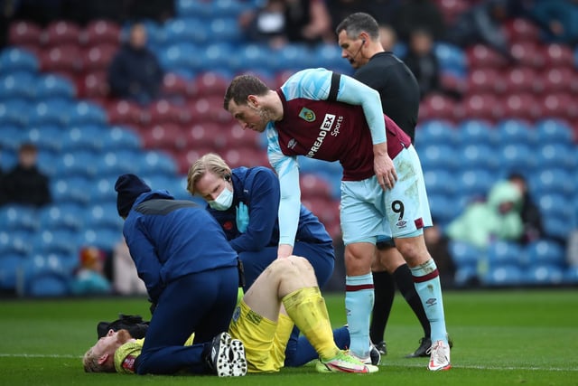 Ryan Schofield of Huddersfield Town receives medical treatment and leaves the field after clashing with Chris Wood of Burnley during the Emirates FA Cup Third Round match between Burnley and Huddersfield Town at Turf Moor on January 08, 2022 in Burnley, England.