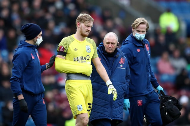 Ryan Schofield of Huddersfield Town receives medical treatment and leaves the field after clashing with Chris Wood of Burnley (not pictured) during the Emirates FA Cup Third Round match between Burnley and Huddersfield Town at Turf Moor on January 08, 2022 in Burnley, England.