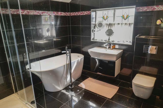 This fully tiled, luxurious facility includes a deep bath and walk-in shower cubicle.
