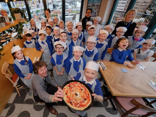 Proudly showing off their pizza!