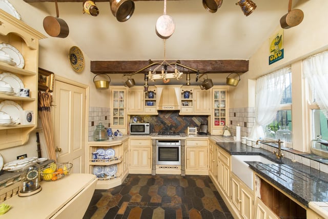 The kitchen is big and full of character thanks to its collection of old copper and brass pans and kettles