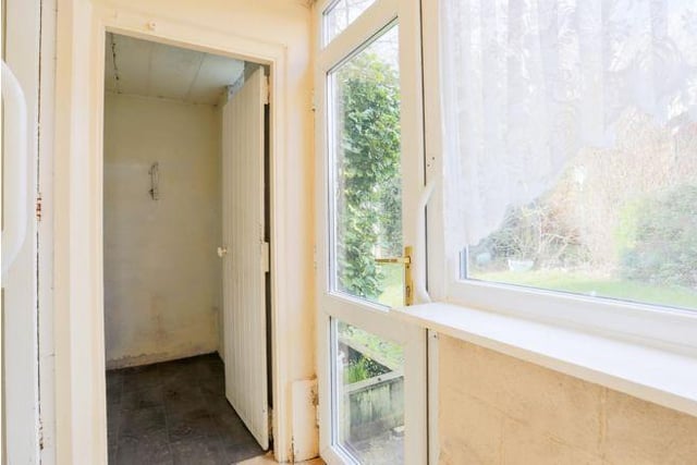 A porch leads out into the back garden, where there are two storage sheds.