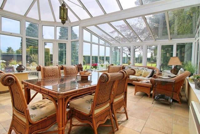 The southerly, spacious conservatory offers spectacular views of the garden with double french doors leading outside. It used as a large living/dining room by the current owners.